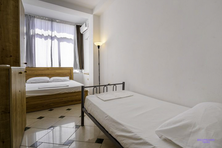 A room with a double and a single bed at the hostel in Sarandë