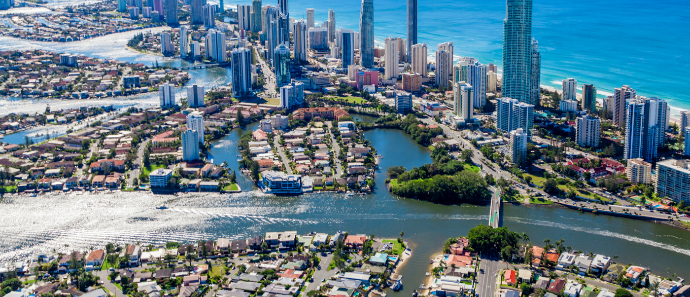 Aerial view of Surfers Paradise, Australia, showing skyscrapers, canals, and the sparkling blue ocean.