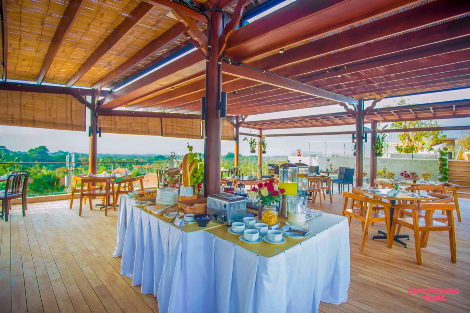 An inviting breakfast buffet on a beautiful open-air terrace overlooking lush greenery in Ubud, Bali.