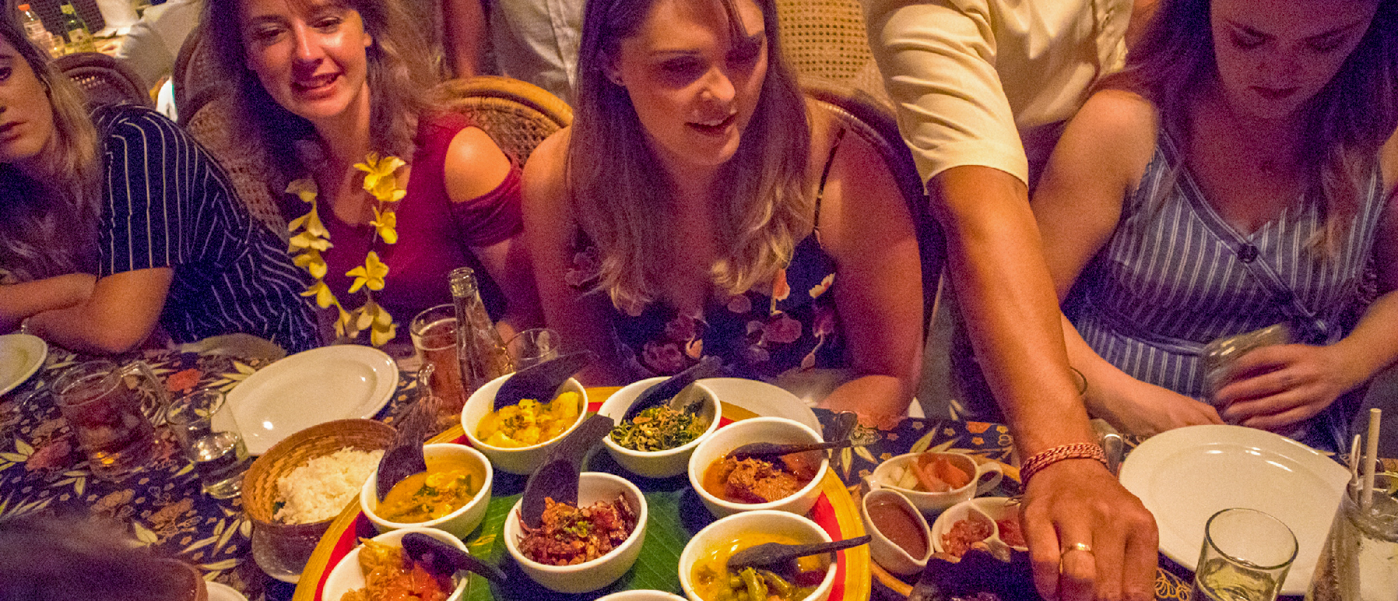 Travelers enjoy a vibrant welcome dinner with many small Balinese dishes in Kuta.