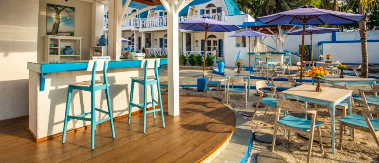 An inviting blue and white outdoor bar and sandy dining area at a resort on Gili Trawangan.