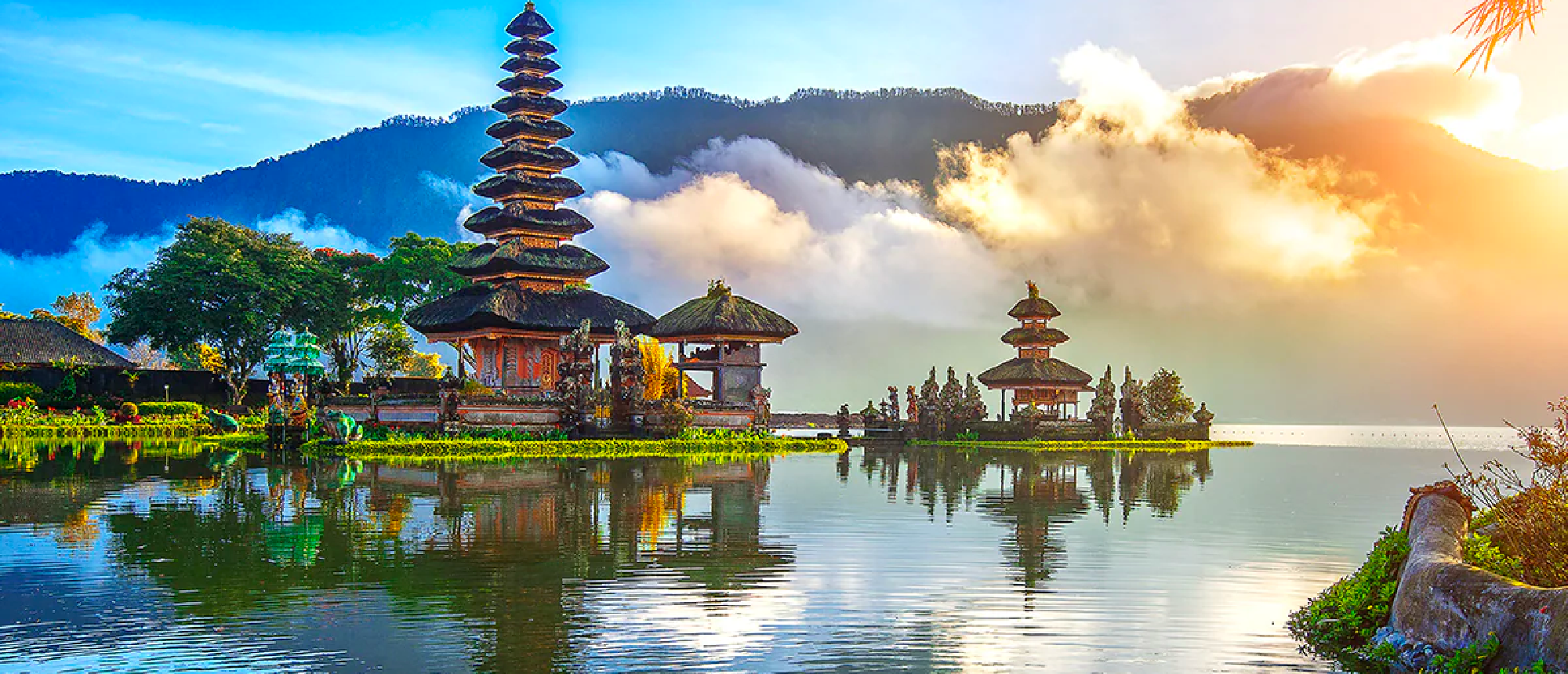 Ulun Danu Beratan Temple on Lake Beratan, Bali, with tiered pagodas reflected in calm water at sunrise.