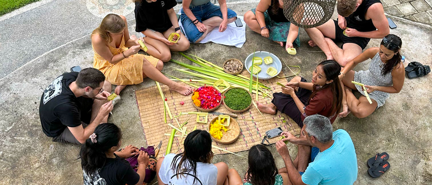 Travelers learn to make traditional Balinese offerings with colorful flowers and leaves in Ubud.