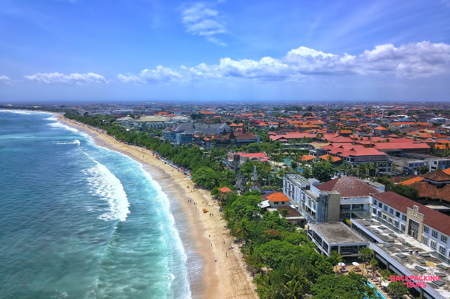 Beautiful aerial view of Kuta Beach in Bali, showing the long sandy shore and vibrant town.