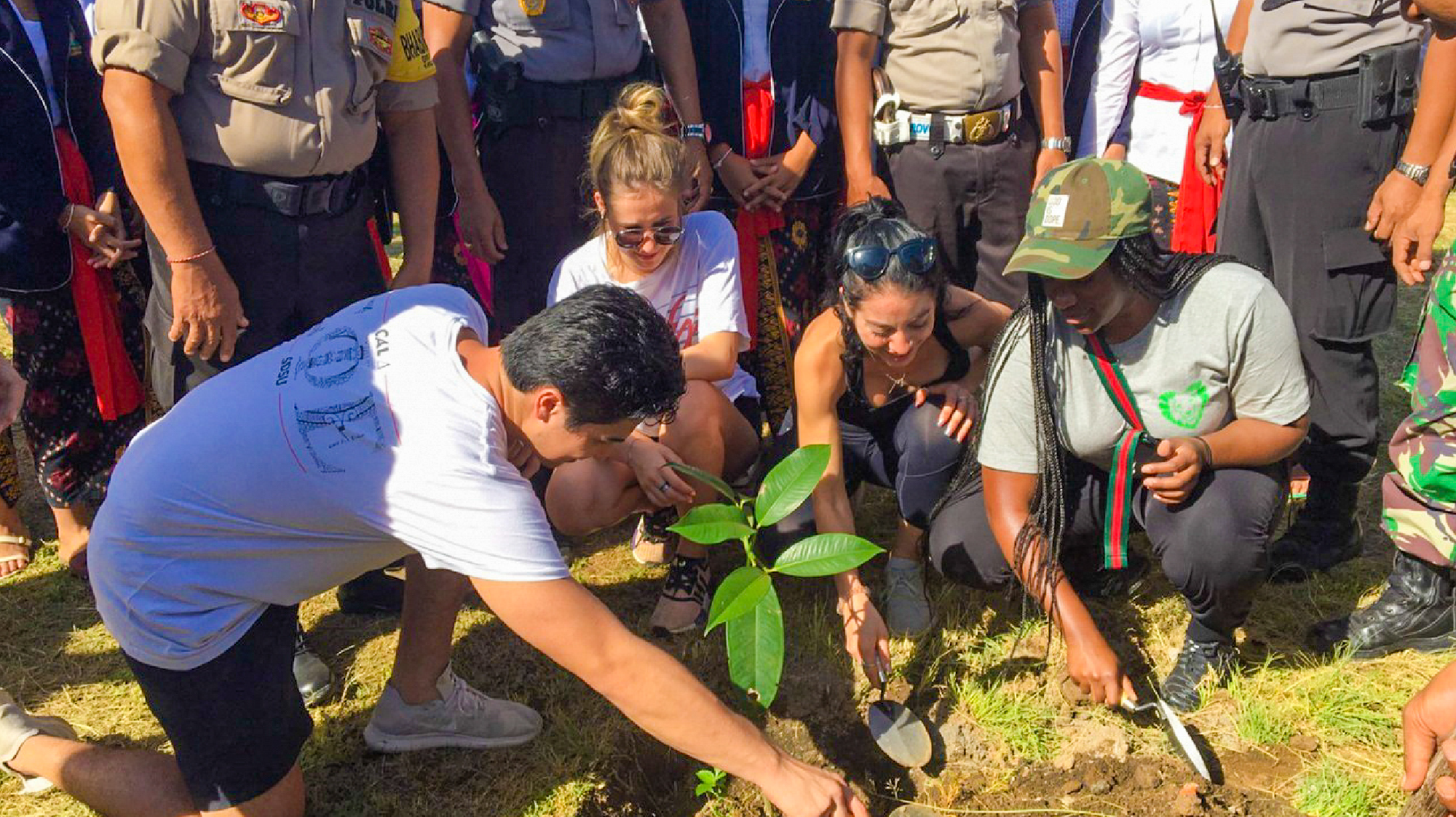Young travelers and locals planting a tree together as part of an environmental education program in Bali.