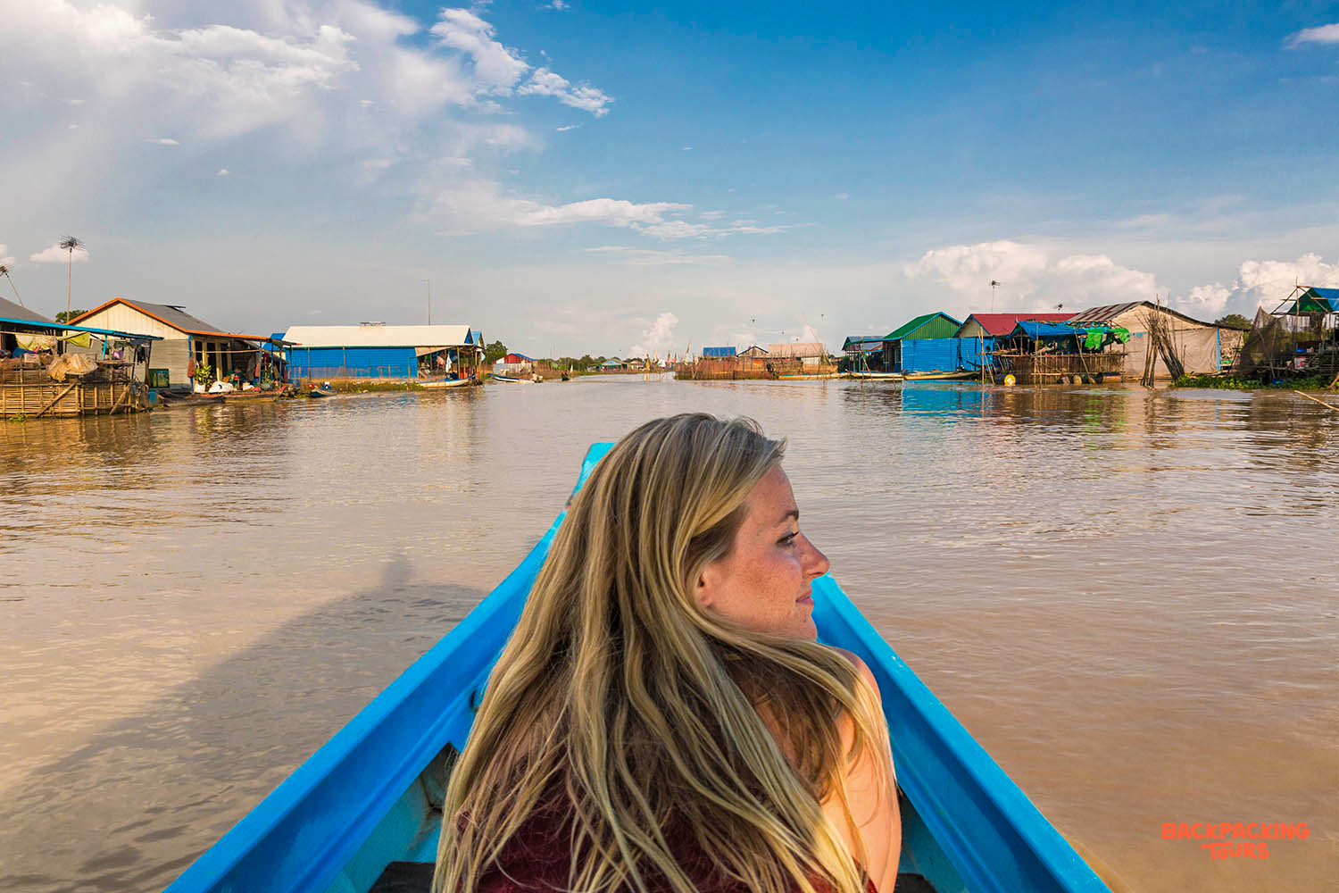 A woman cruises through a peaceful floating village in Siem Reap, Cambodia, enjoying rural life.