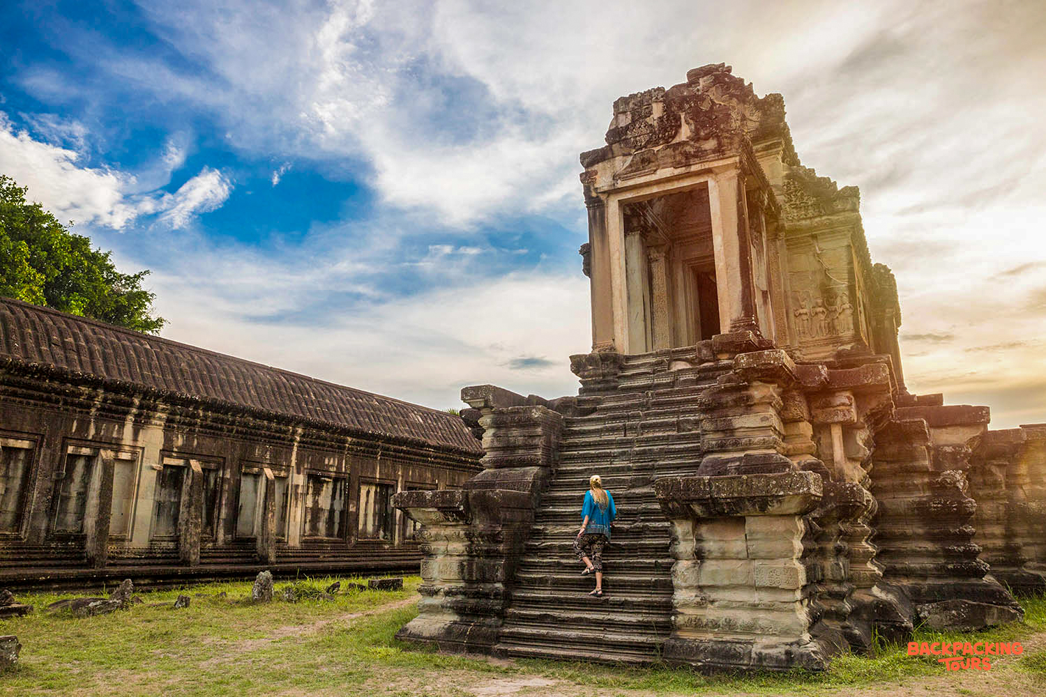 A traveler climbs the grand stone steps of an ancient temple, exploring Angkor Wat in Cambodia.