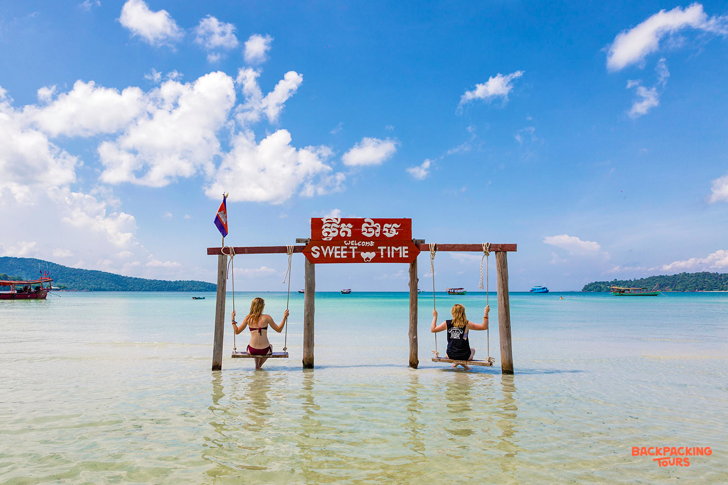 Friends relax on swings in the clear turquoise waters of Koh Rong, Cambodia, enjoying sweet island time.