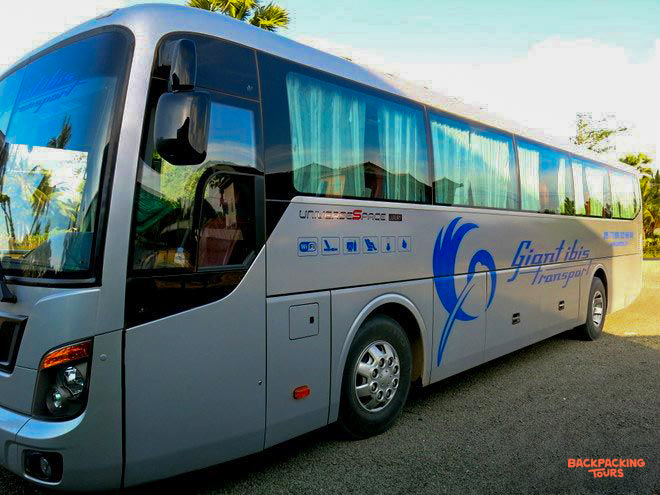 A modern silver Giant Ibis overnight bus, ready for a long journey across Cambodia.