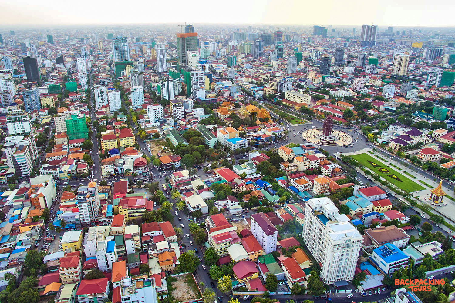 An expansive aerial view of the bustling Phnom Penh cityscape, with countless buildings and busy roads.