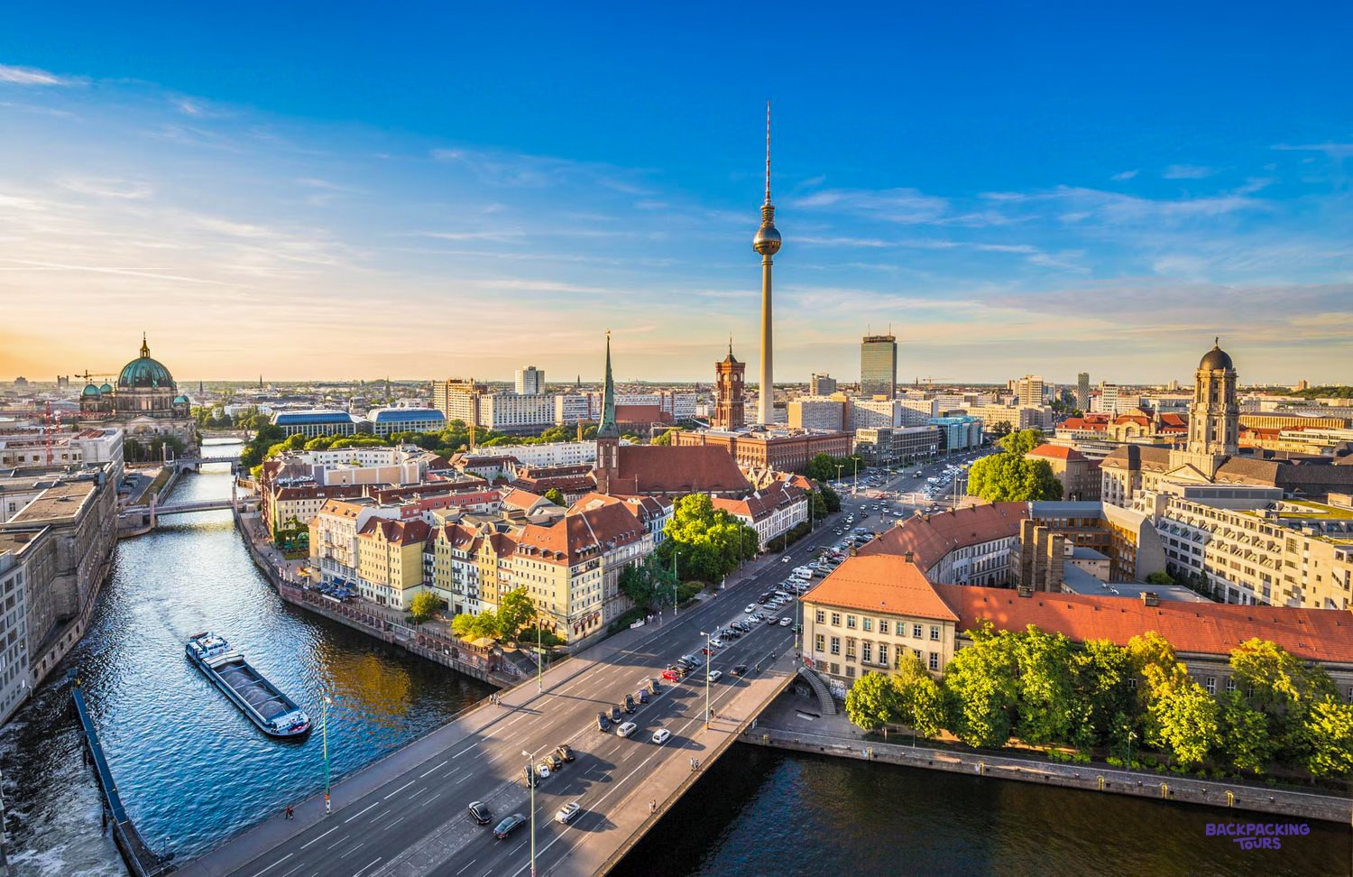 The Spree winds through central Berlin at sunset, with the TV Tower rising above the rooftops.