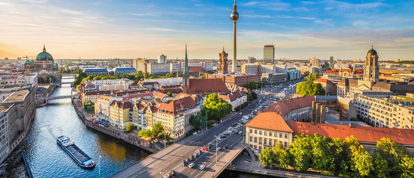 The Spree winds through central Berlin at sunset, with the TV Tower rising above the rooftops.