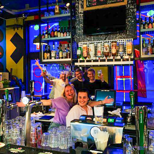 Travellers cheering at the colourful bar of the Amsterdam hostel