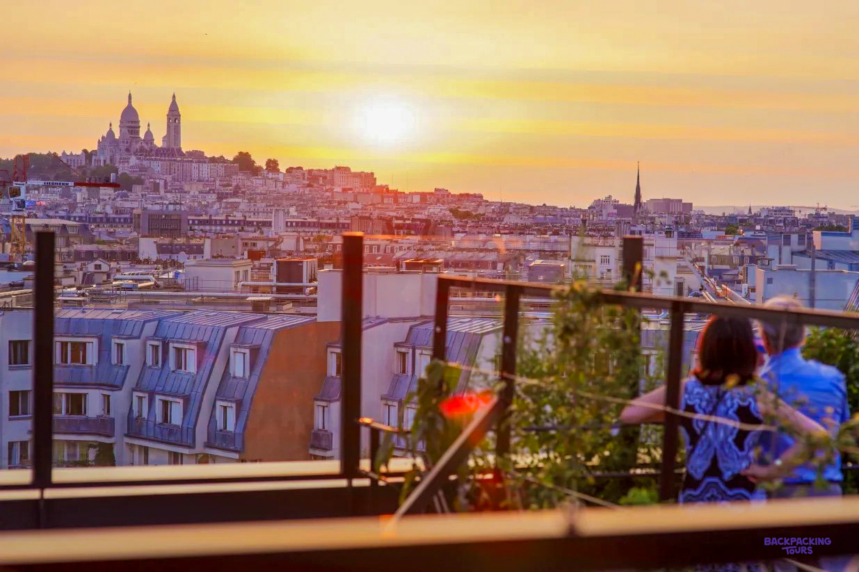 The sun setting over the rooftops of Paris and the Sacré-Cœur, from the terrace of the hostel