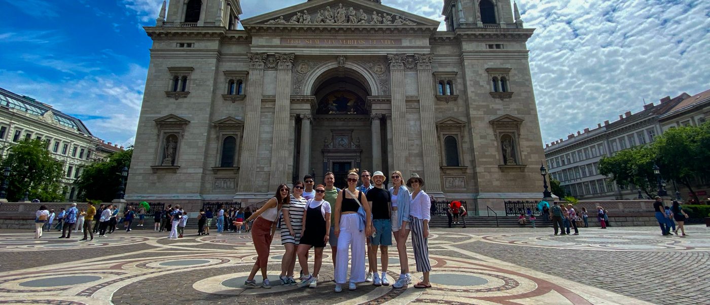 A group of travellers stands in front of St Stephen's Basilica in Budapest.