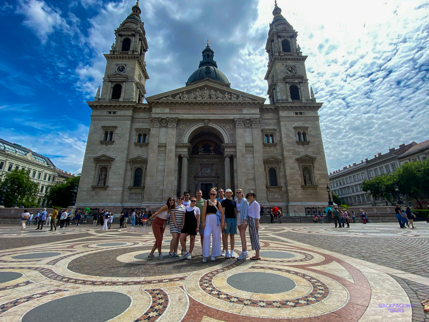 A group of travellers stands in front of St Stephen's Basilica in Budapest.