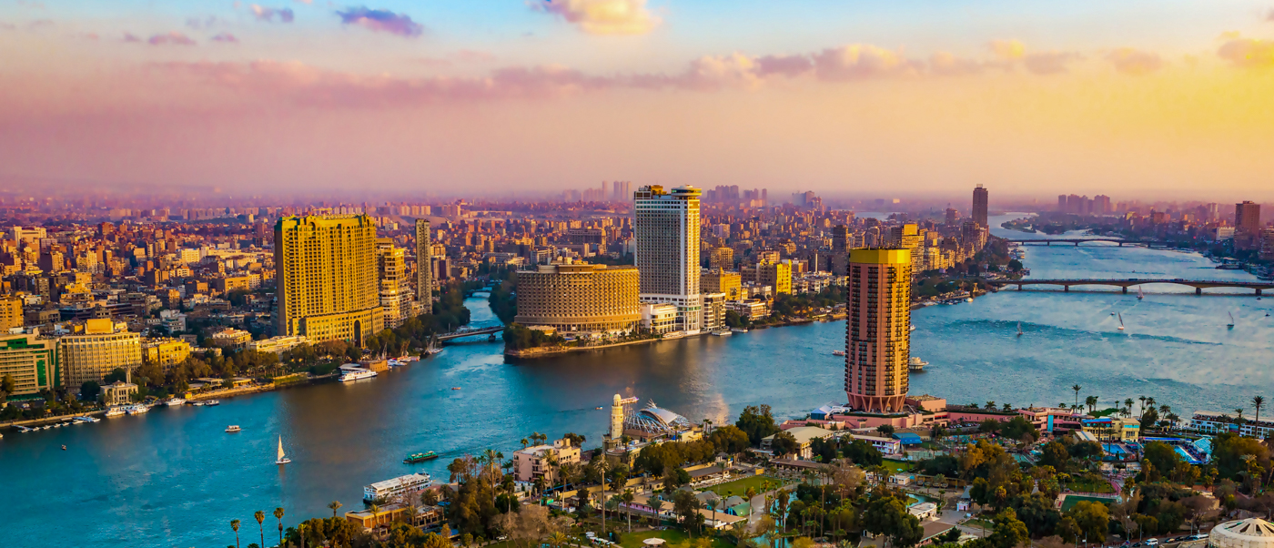 Beautiful sunset over Cairo city, with the Nile River, bridges, and many tall buildings.
