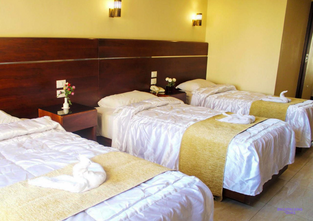 A triple room with white beds at the hotel in Cairo