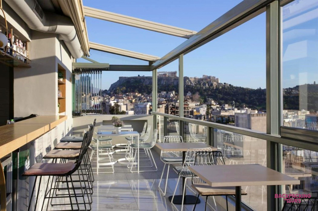 Modern rooftop bar in Athens with comfortable seating and a spectacular panoramic view of the Acropolis.