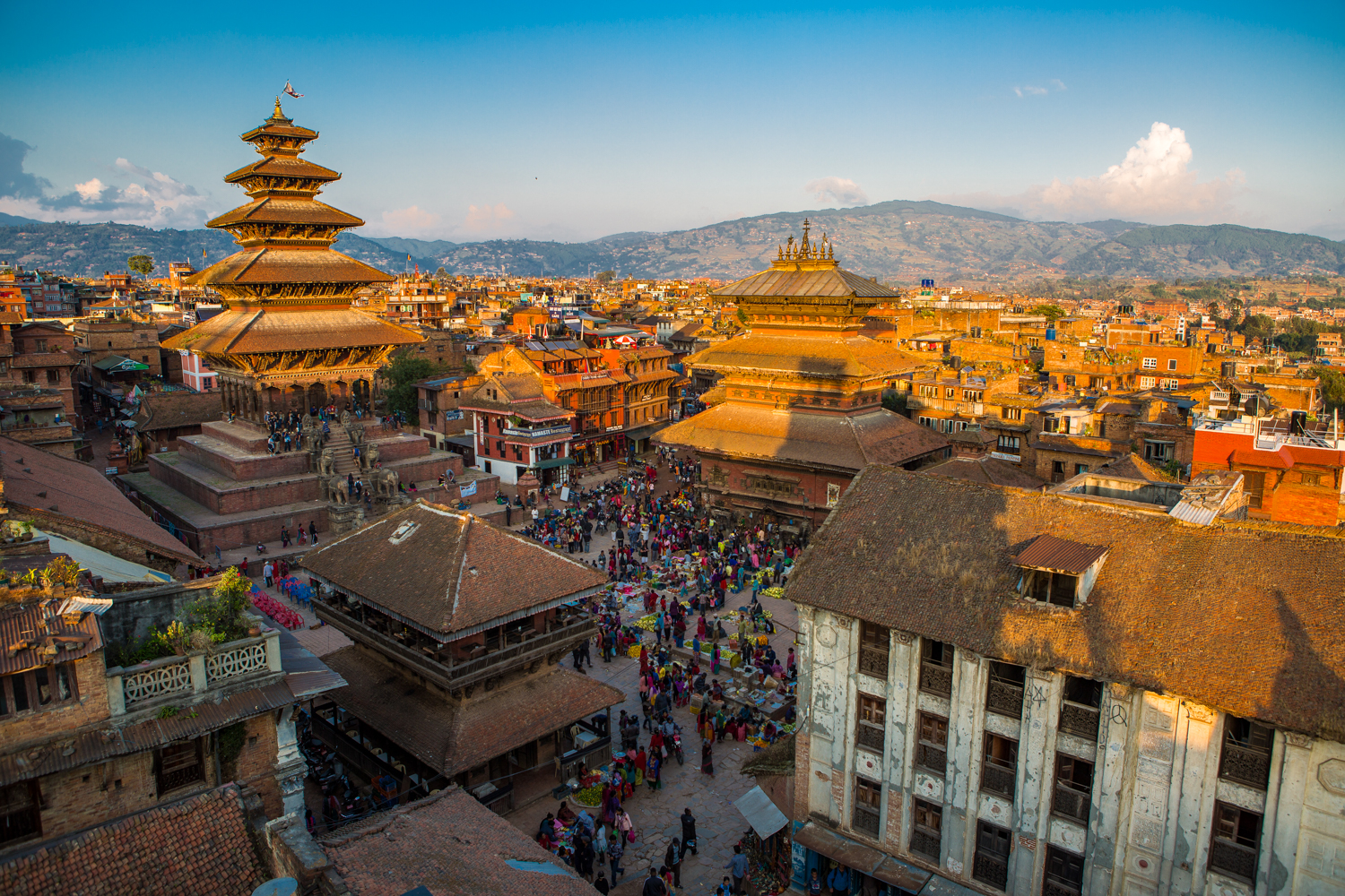 Bustling Kathmandu Durbar Square with ancient tiered temples, traditional buildings, and many people.