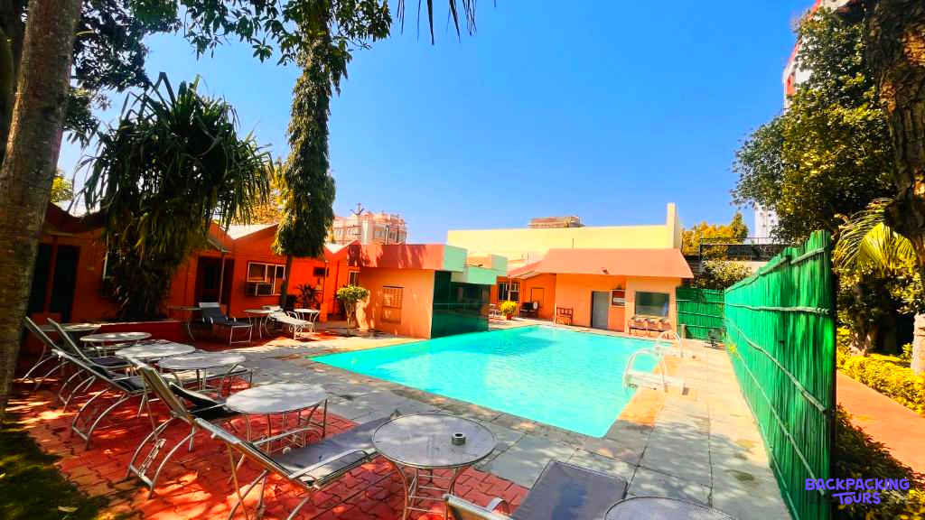 Enjoy the inviting blue swimming pool and lounge area at a colorful guesthouse in Pushkar.