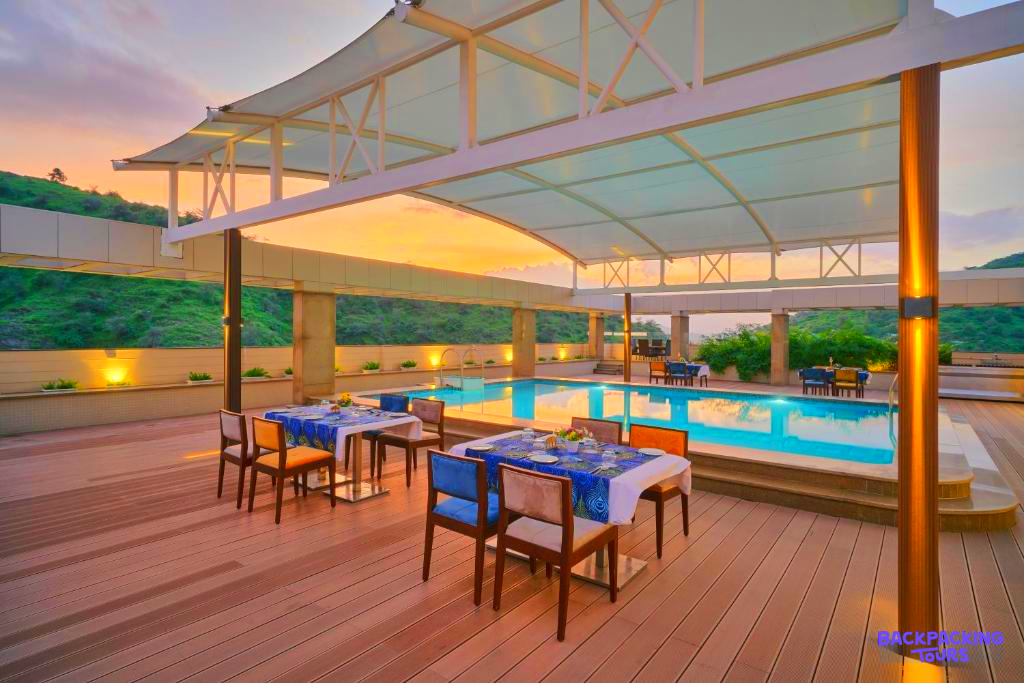 Relaxing rooftop pool and dining area with stunning sunset views over Udaipur.