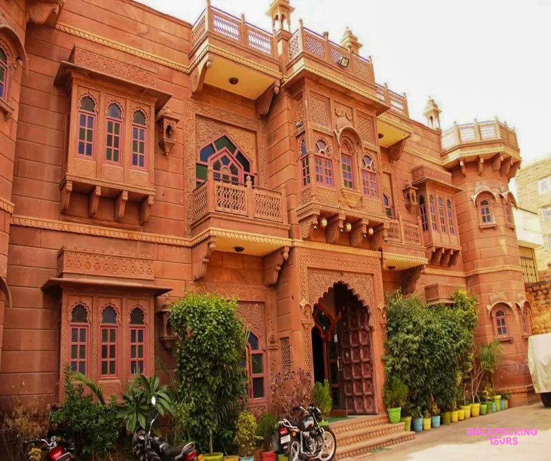 A grand traditional haveli in Jodhpur, featuring ornate red sandstone architecture and intricate carvings.