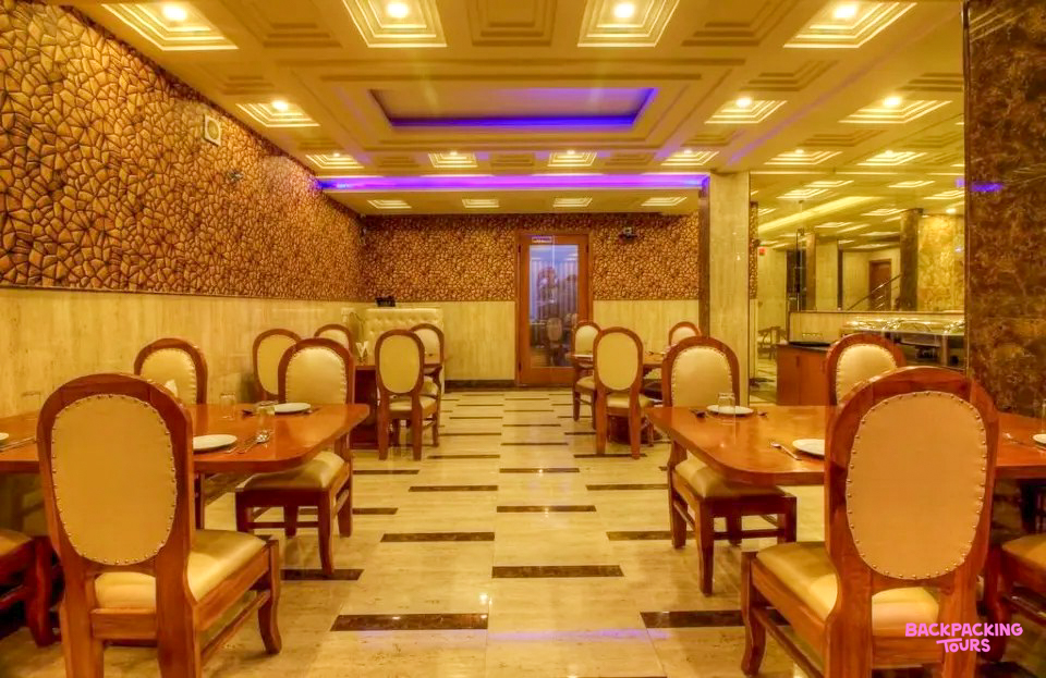 Traditional haveli dining room in Jodhpur, featuring ornate walls and elegant wooden tables set for dinner.