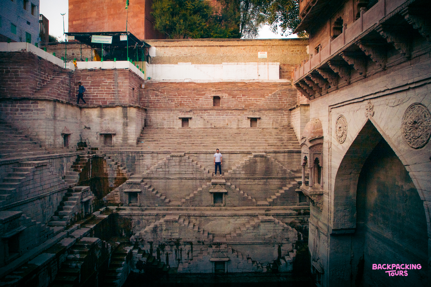 A lone traveler stands in the impressive, multi-tiered stepwell, a historic landmark in Jodhpur.