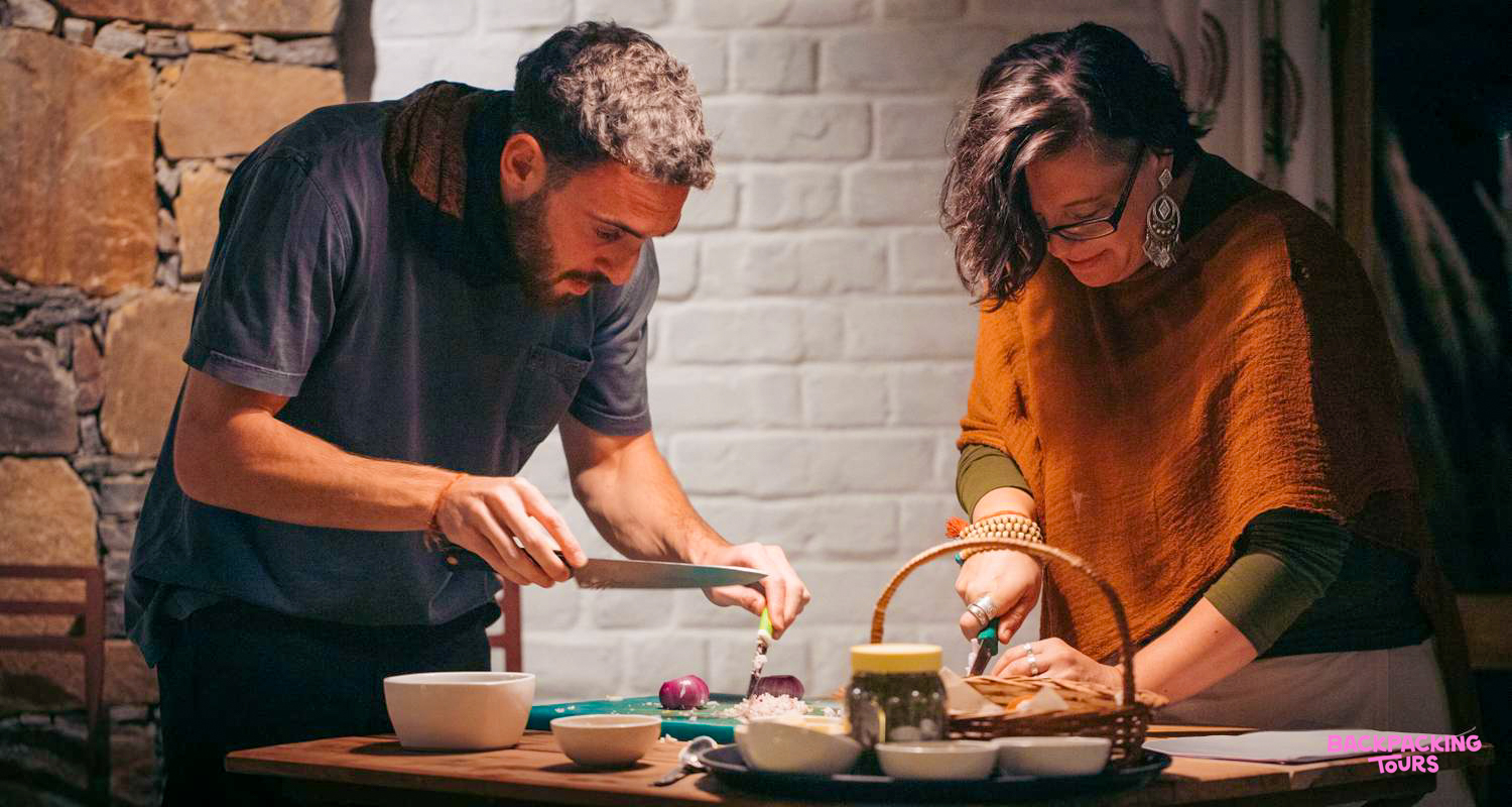 A man and woman chop vegetables together during an engaging cooking class in Udaipur.