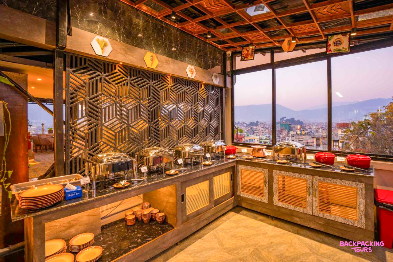 A stylish buffet spread in a contemporary Kathmandu restaurant, offering city views at dusk.