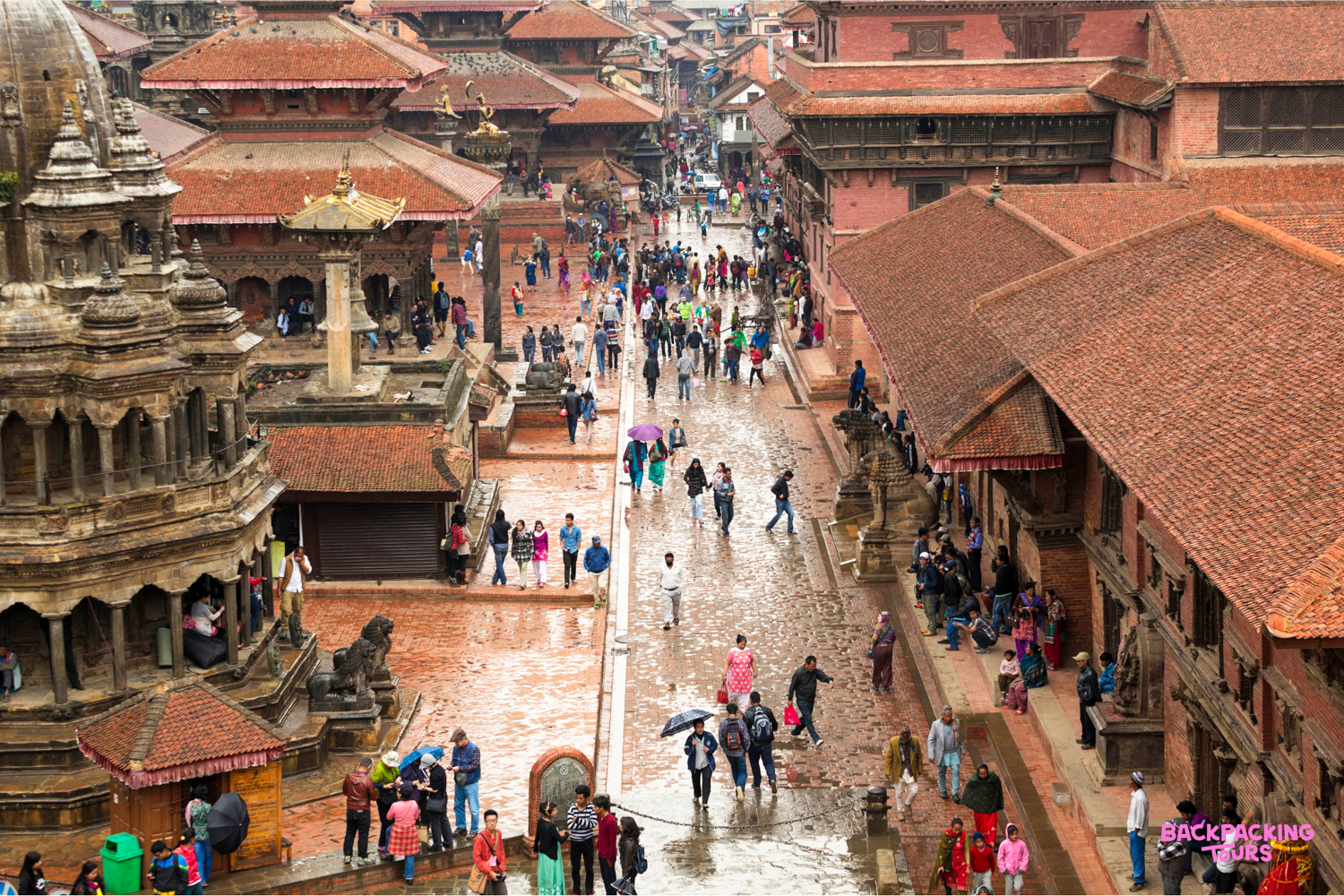A vibrant scene in Kathmandu Durbar Square, with ancient temples, traditional red-roofed buildings, and many people.