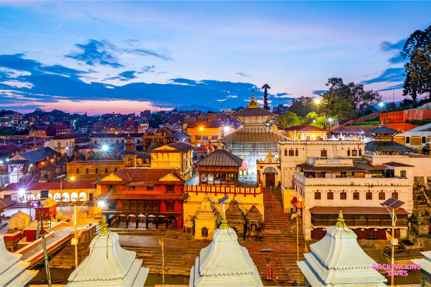 Kathmandu's vibrant cityscape at dusk, with traditional temples and buildings glowing under a twilight sky.