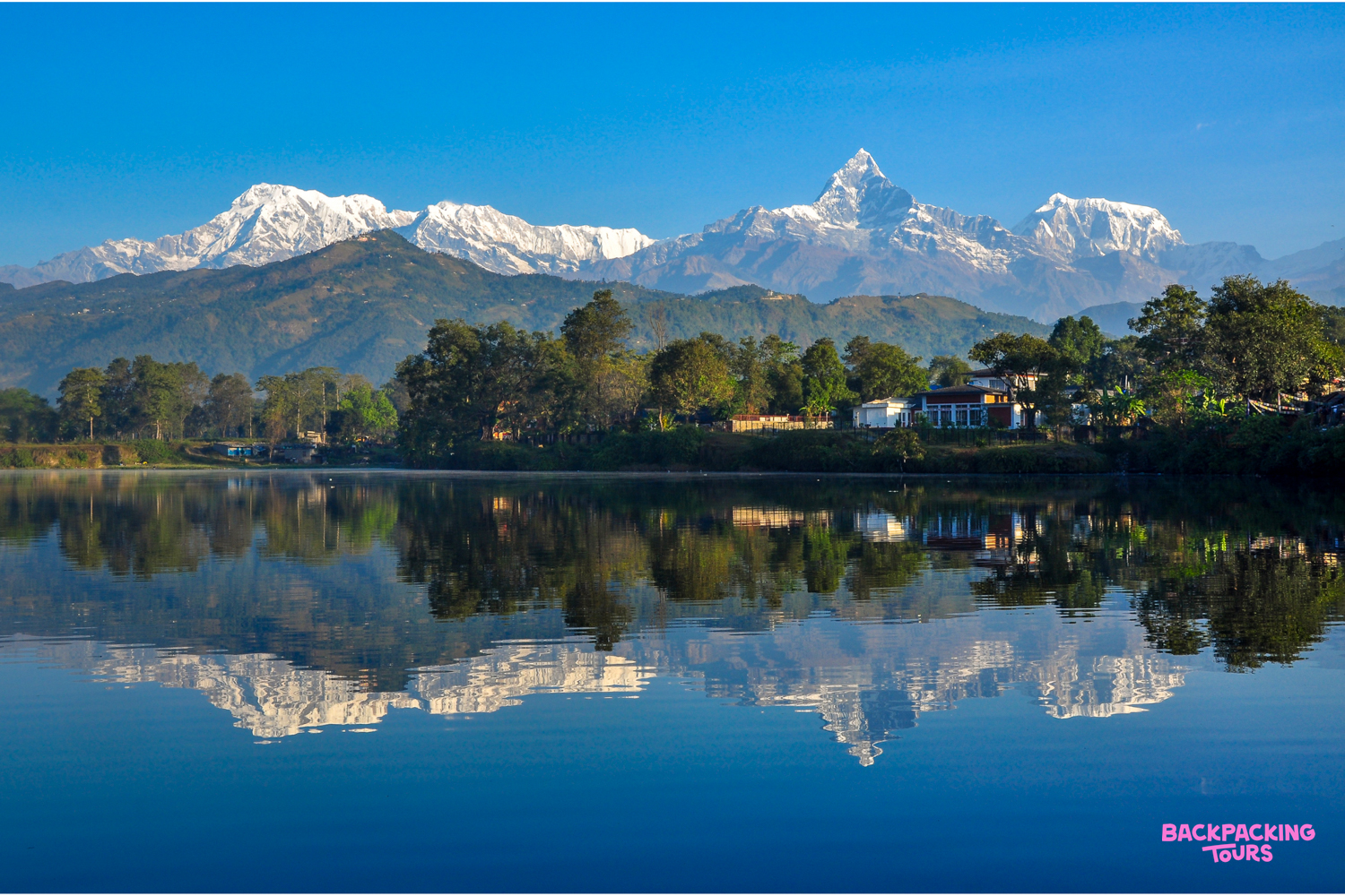 Snow-capped Annapurna mountains beautifully reflected in the tranquil waters of Phewa Lake in Pokhara.