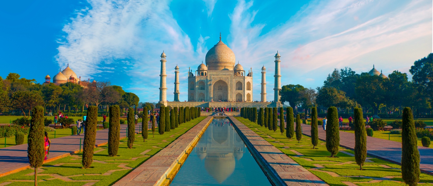 Grand Taj Mahal in Agra, India, with its white marble dome, reflecting pool, and lush gardens.