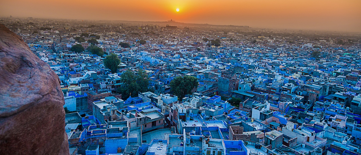 A breathtaking panoramic view of Jodhpur's blue city at sunset from a high vantage point.