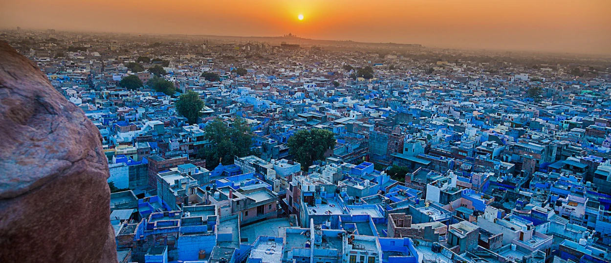A breathtaking panoramic view of Jodhpur's blue city at sunset from a high vantage point.