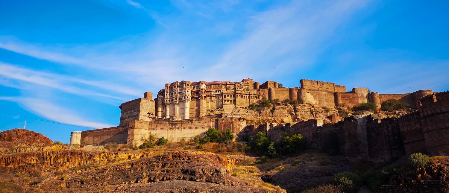 The imposing Mehrangarh Fort rises from a rocky hill under a clear blue sky in Jodhpur.
