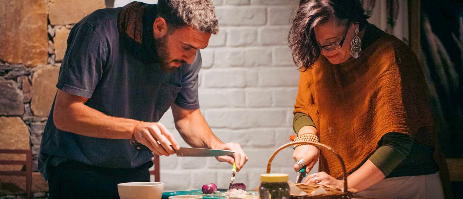 A man and woman chopping vegetables together during a cooking class in Udaipur, India.