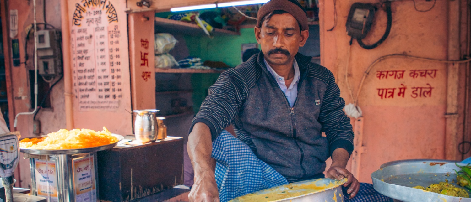 A street vendor prepares traditional Indian sweets at a small food stall in Delhi.