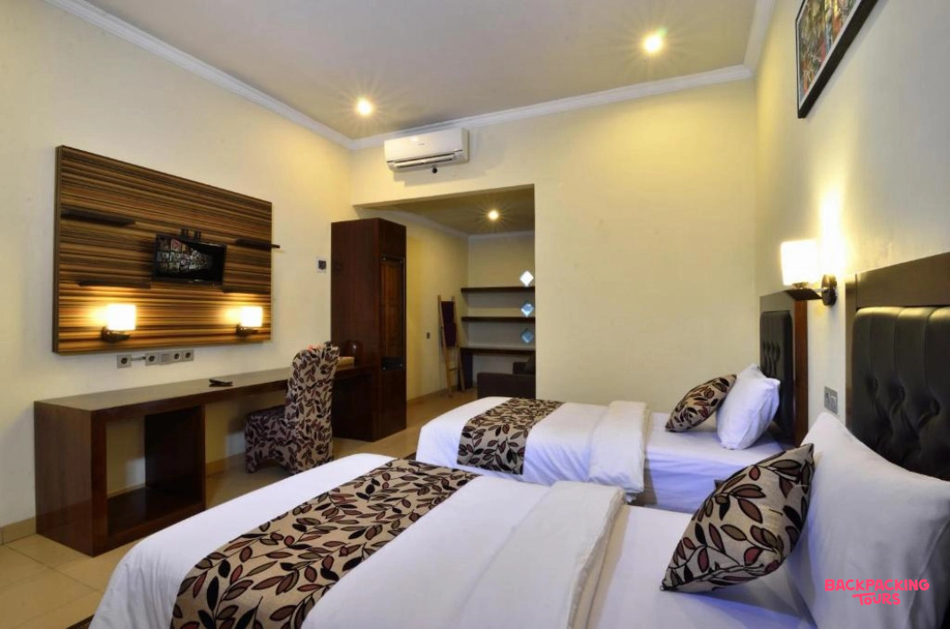 A well-appointed hotel room in Lombok with two comfortable beds, a desk, and modern amenities.