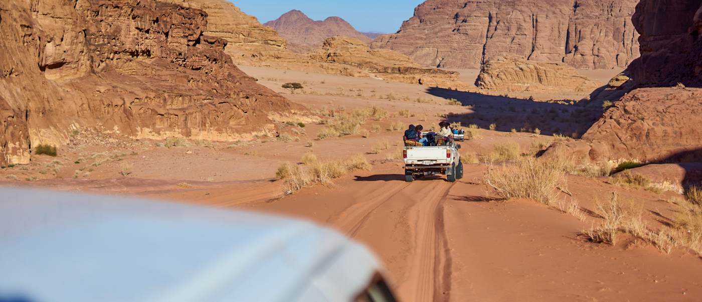 People enjoy a desert safari in jeeps, exploring the stunning red landscapes of Wadi Rum.