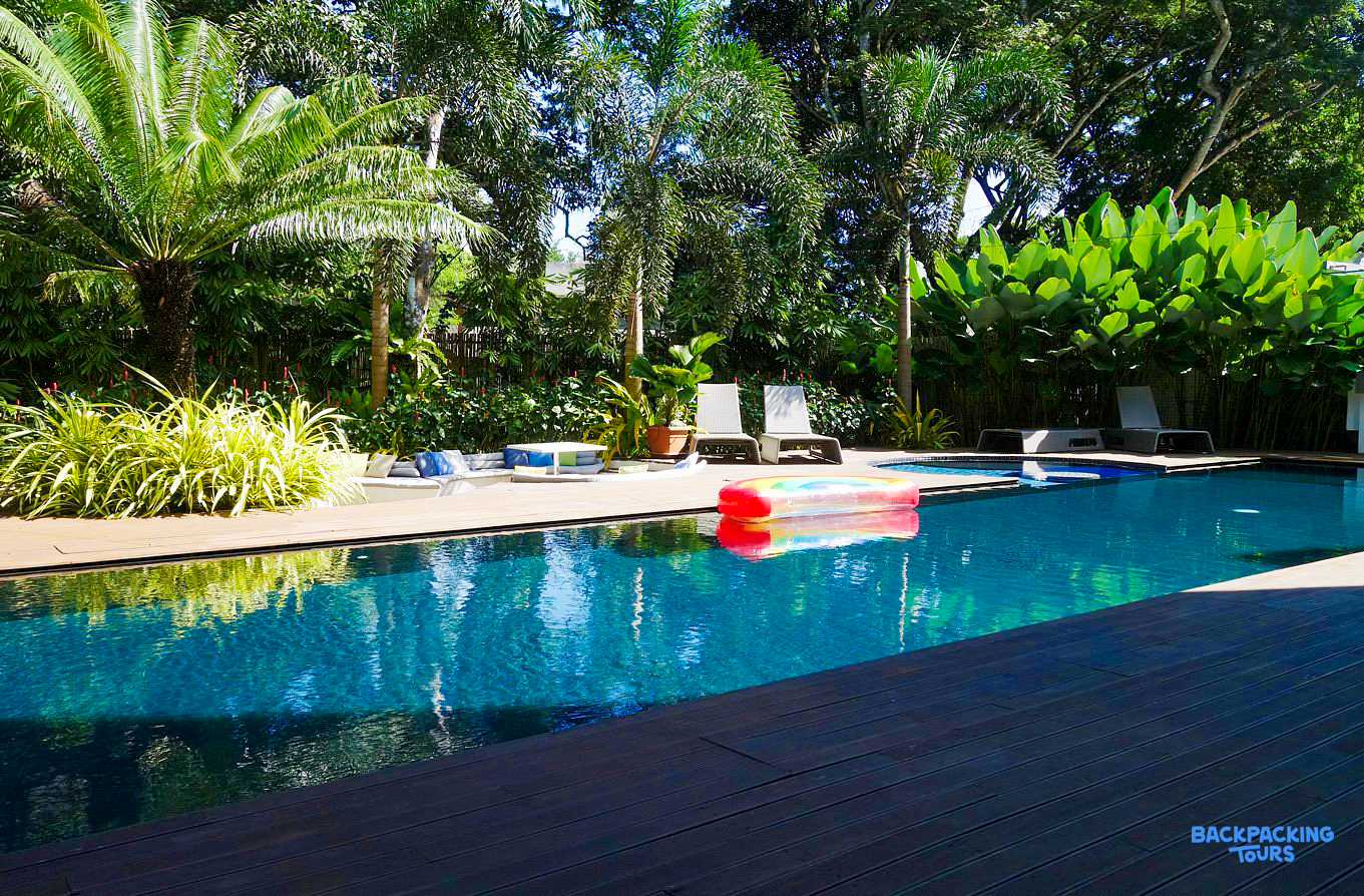 Clear blue swimming pool with an inflatable raft, sun loungers, and tropical trees in Puerto Princesa.