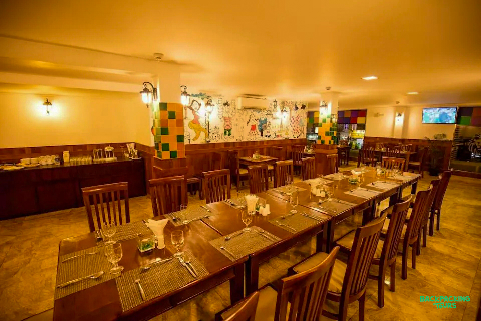 Inviting dining room in Nuwara Eliya accommodation, set with long tables and vibrant wall murals.
