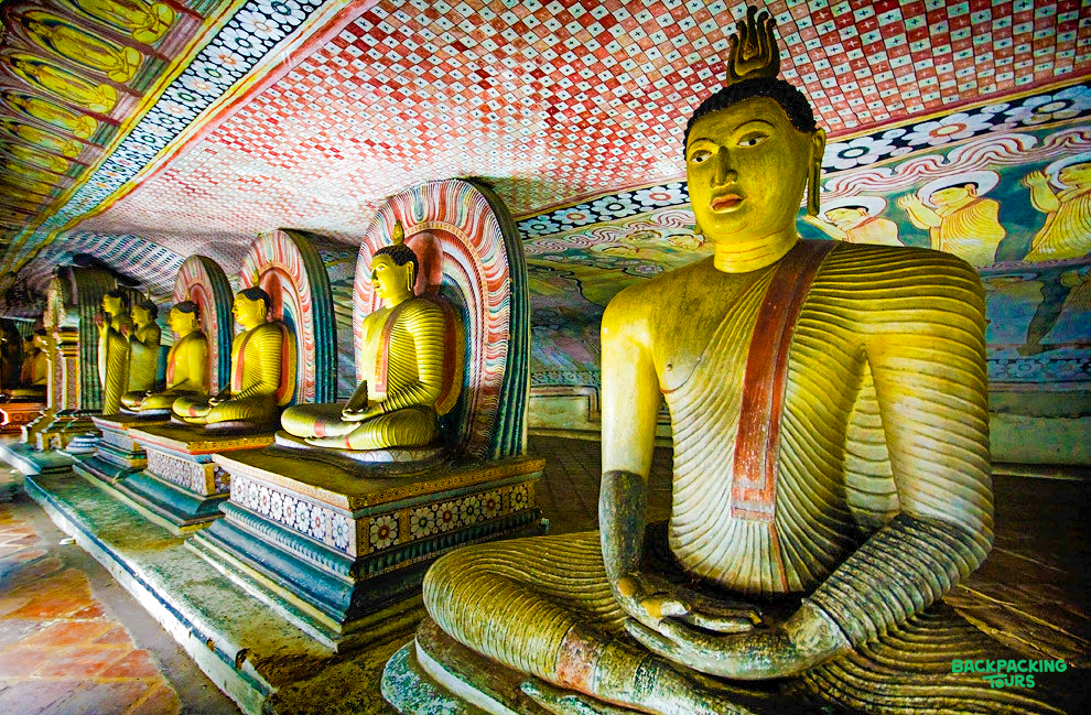 Serene golden Buddha statues line the ancient, painted Dambulla Cave Temple in Sri Lanka.