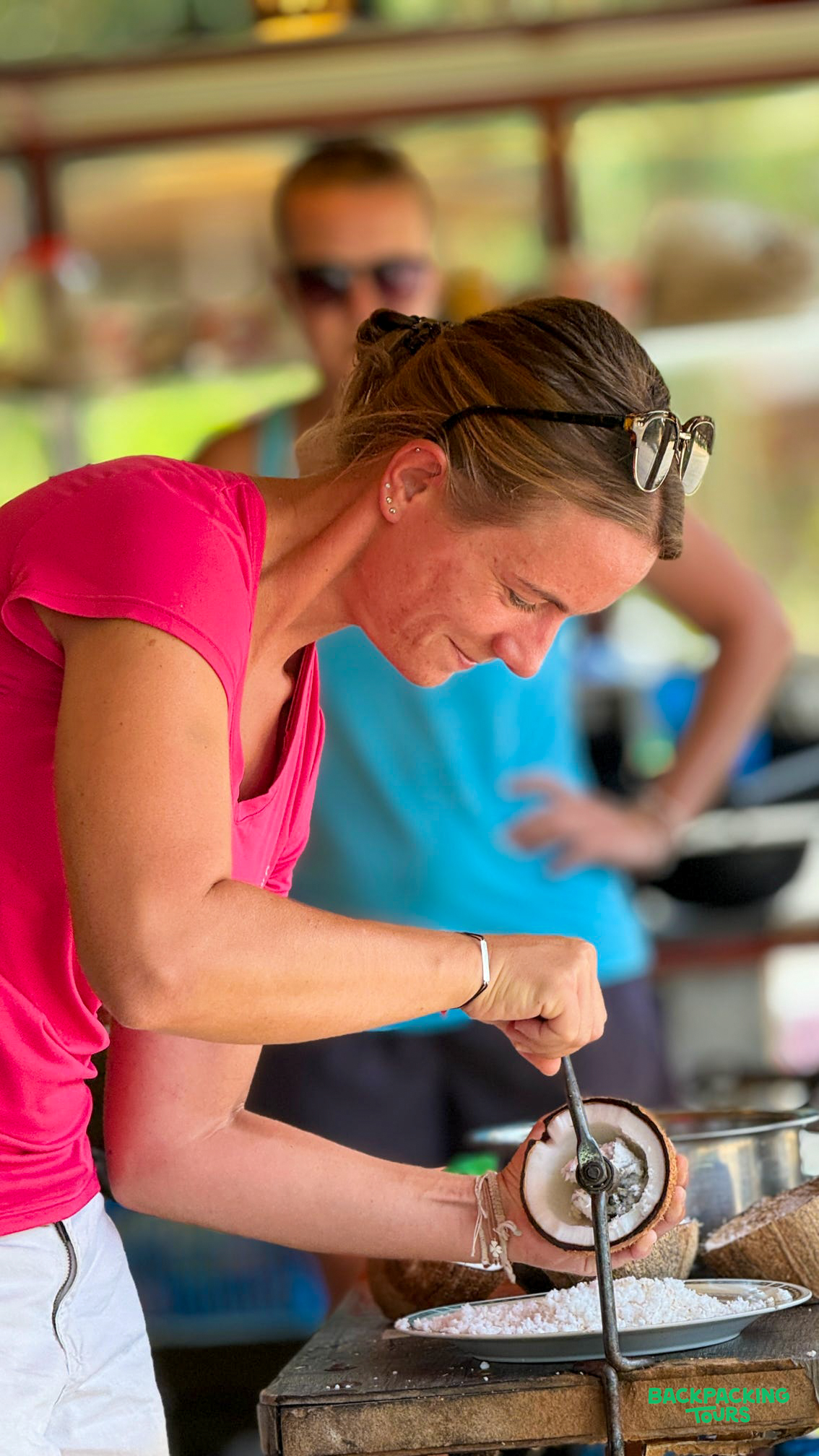 Traveler learns to grate fresh coconut by hand during a hands-on cooking experience in Sigiriya.