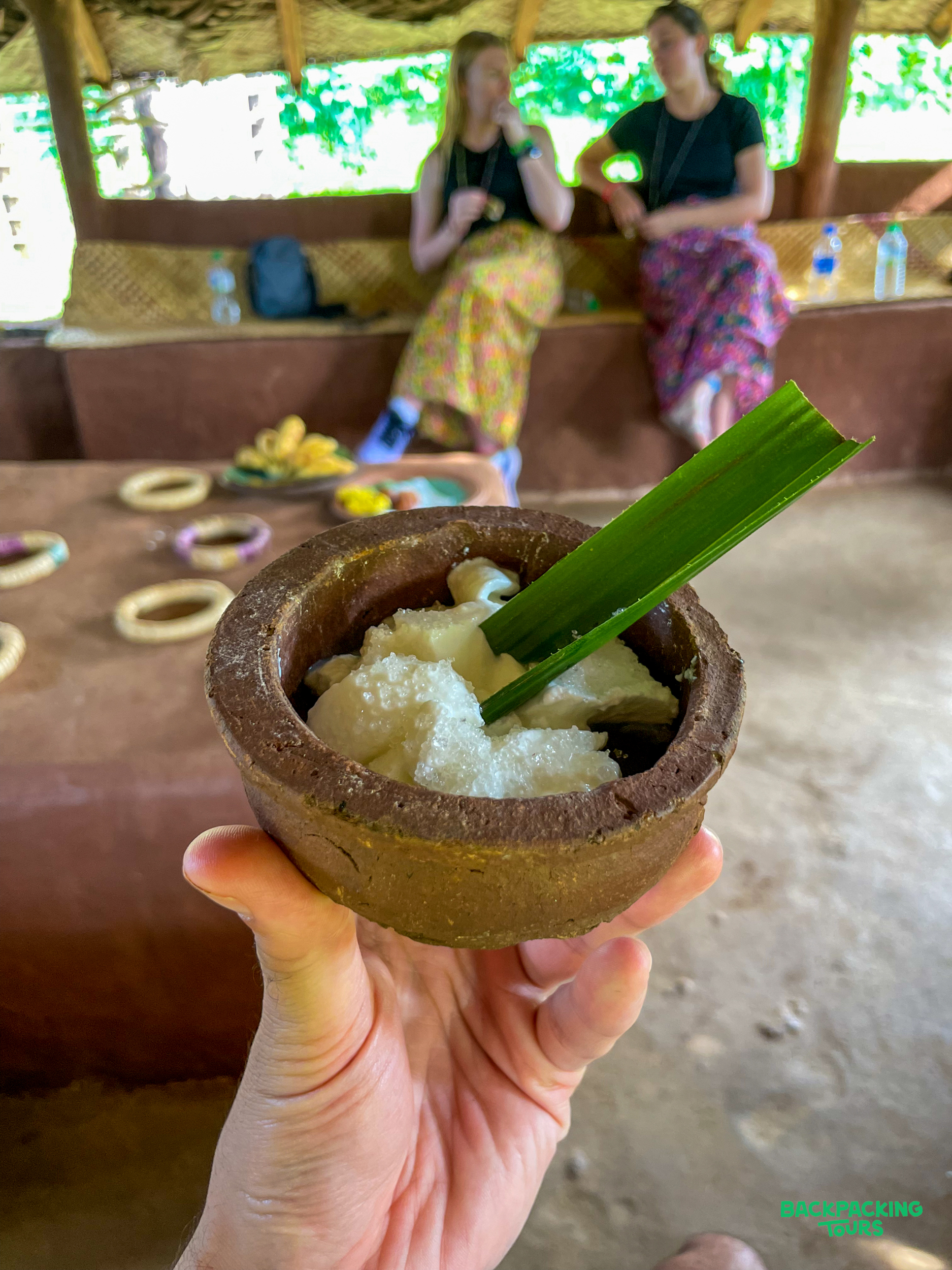 Tasting a traditional snack served in a rustic bowl during a village tour in Kandy.