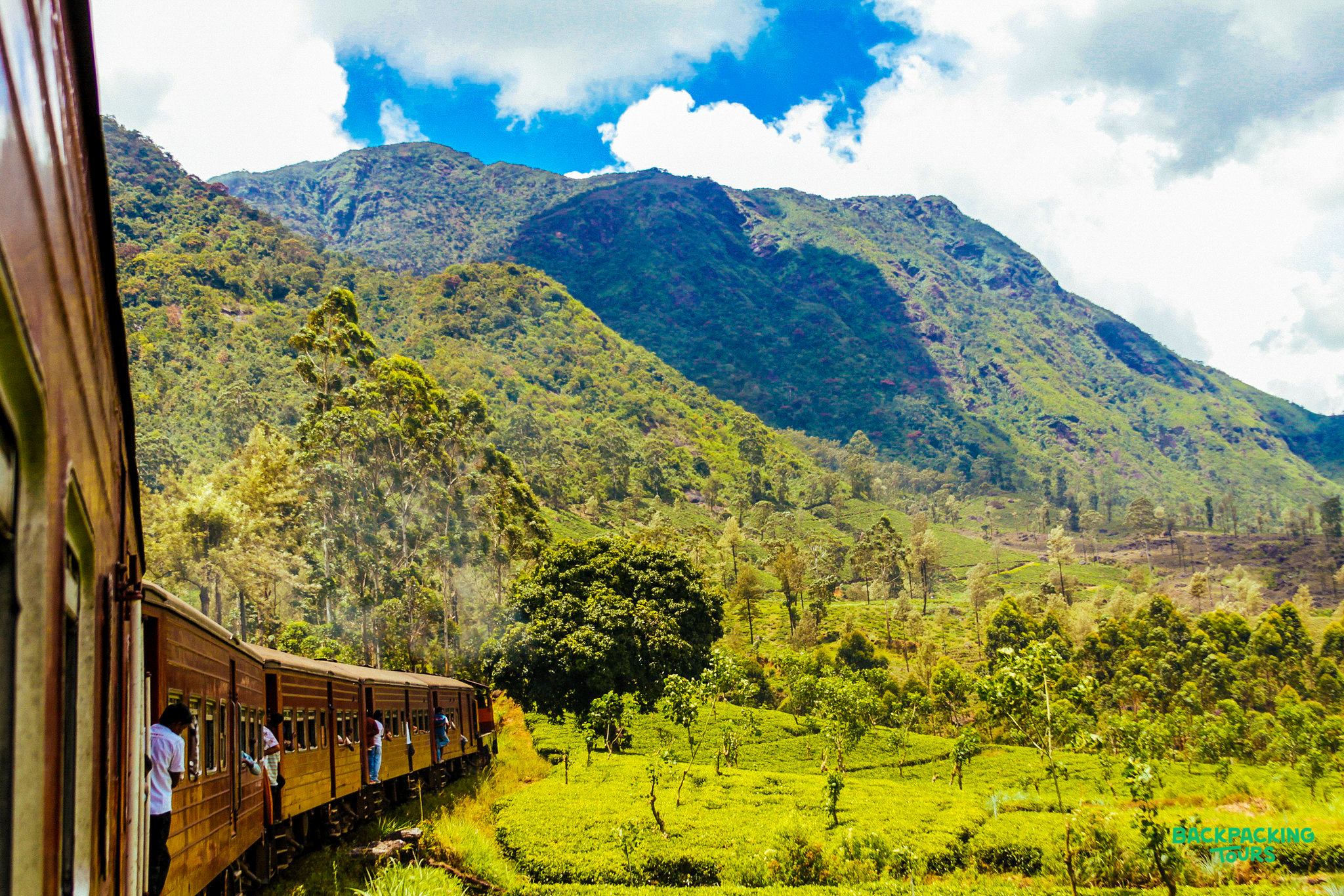 A scenic train journey through the vibrant green tea plantations and mountains of Nuwara Eliya, Sri Lanka.