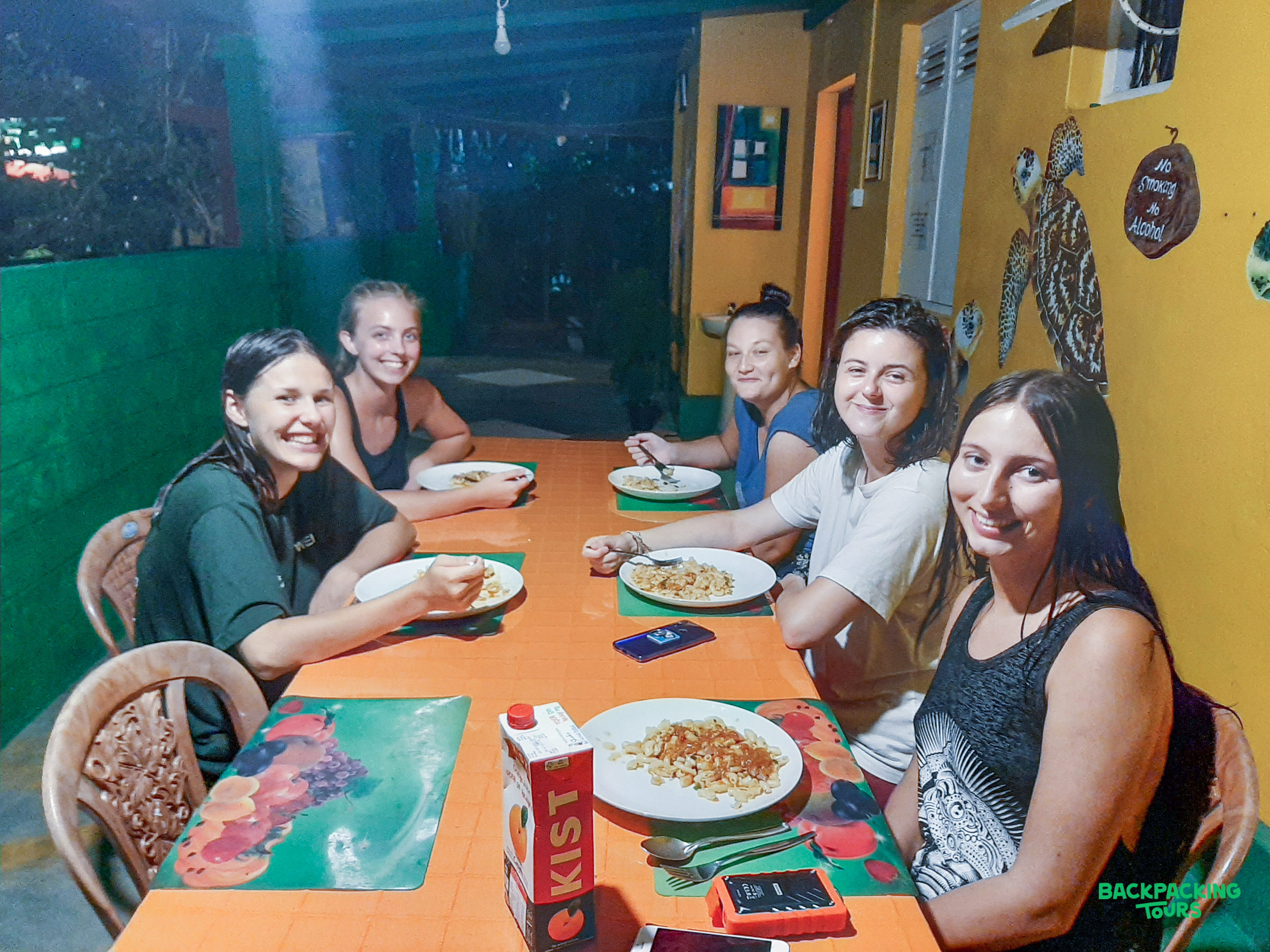 Six happy young women enjoying a delicious homemade Sri Lankan dinner at their guesthouse.
