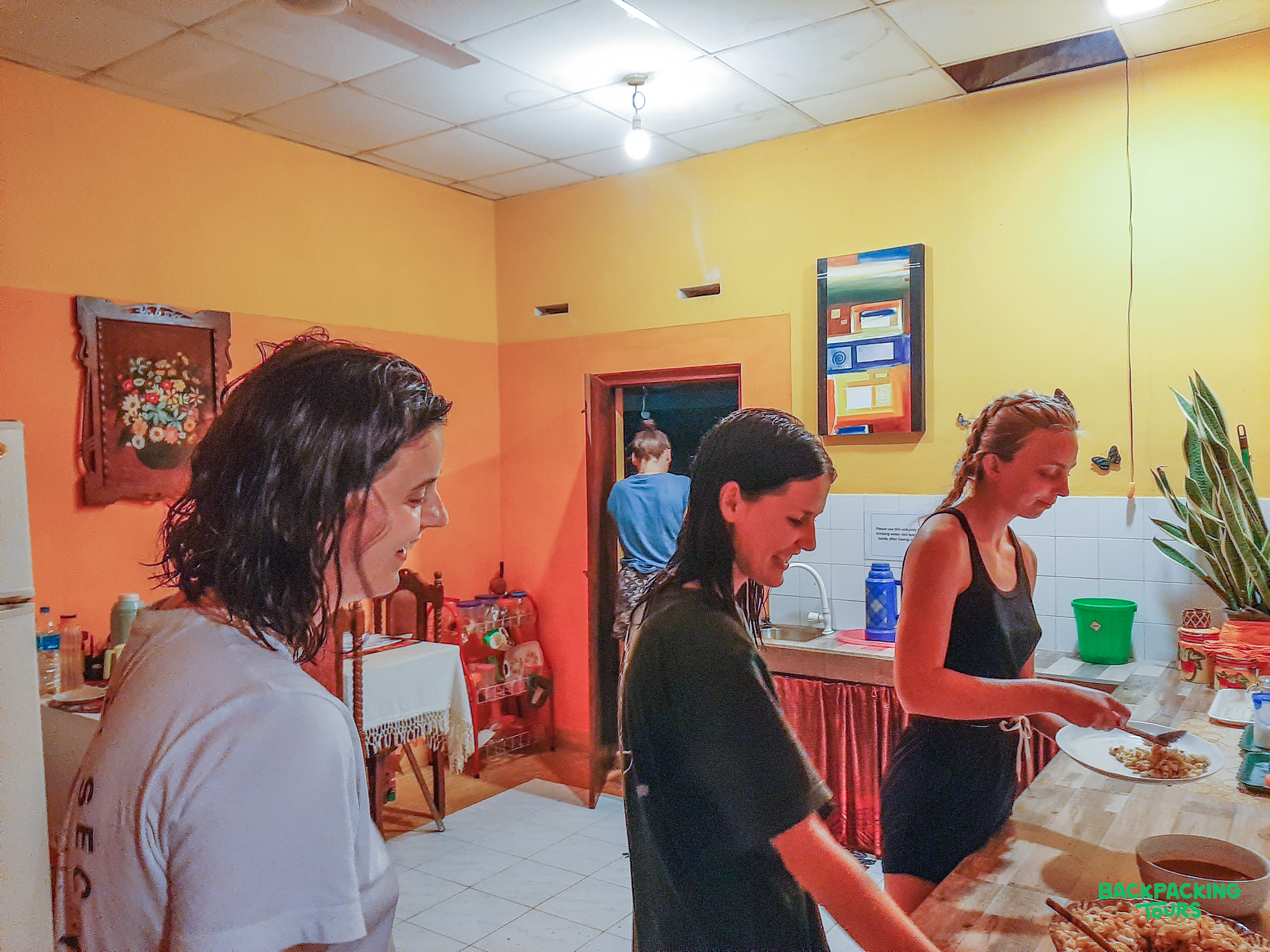 Three women happily prepare a delicious homemade meal in a warm Sri Lankan kitchen.